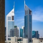 Striking view of the Emirates Towers in Dubai against a clear blue sky, highlighting modern architecture.